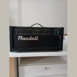 Černý kytarový zesilovač s bílým nápisem Randall na přední straně. V horní části je ovládací panel s modely a nápisy OVERDRIVE CHANNEL, CLEAN CHANNEL…