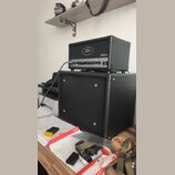 Černý kytarový kombo zesilovač s látkovou mřížkou a ovládacím panelem. Na přední straně je bílé logo "Peavey" v oválu a nápis "800". Pod ovládacími p…