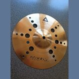 Zlatavý kovový činel s otvory různých velikostí v celém těle. Na povrchu je nápis XIST 10" ION Splash s trojúhelníkovým logem a v dolní části nápis i…