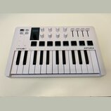 Bílá klaviatura s nápisy MINILAB 3 a ARTURIA. Horní panel obsahuje osm otočných knoflíků, čtyři posuvníky a osm čtvercových tlačítek. V levé části js…