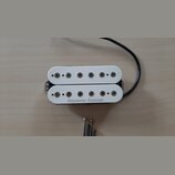 Bílý humbucker s dvěma řadami šesti polových magnetů. Na spodním rámečku je černý nápis Seymour Duncan. K snímači vede černý kabel a vedle něj jsou p…