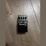 Černý kytarový efekt reverb značky Boss, model RV-5. Na horní straně jsou tři ovládací knoflíky s popisky LEVEL, TONE a TIME, kontrolka CHECK a přepí…