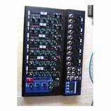 Černý mixážní pult s modrým rámem. Na pravé straně jsou vstupní konektory XLR a jack, v dolní části je digitální displej. Ovládací panel obsahuje pos…