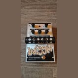 Kytarový efekt s bílým kovovým šasi a černými ovládacími knoflíky. Na spodní části je velký nápis Wiggler a logo electro-harmonix s textem MADE IN NY…