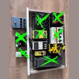 Fotografie zobrazuje několik kytarových efektů v dřevěné šasi a vedle něj. V šasi jsou umístěny pedály s nápisy "overdrive", "NUX", "DRIVE" a "Noise…