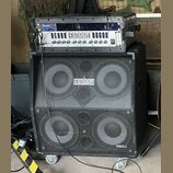 Fotografie zobrazuje basový zesilovač a reproduktorovou skříň v černém provedení. Na horním zařízení je nápis FENDER BASS AMPLIFICATION a pod ním ozn…