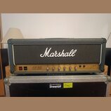 Kytarový zesilovač značky Marshall v šedém provedení s černou síťovkou. Na zlatém ovládacím panelu je nápis JCM 800 LEAD SERIES a řada ovládacích kno…
