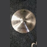 Kruhové činely z kovu s broušeným povrchem a nepravidelným okrajem. Na spodní části je černý nápis istanbul Agop Made in Turkey. V horní části je vid…