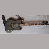 Tmavě hnědá elektrická kytara s výraznou sletovanou strukturou dřeva na těle. Na hlavě je viditelné logo Ltd. Kytara má dva humbuckery, most s tajnou…