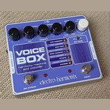 Modrý efektový pedál s bílým nápisem VOICE BOX a podtitulem harmony machine and Vocoder. Na spodní straně je logo electro-harmonix a dvě stříbrná tla…