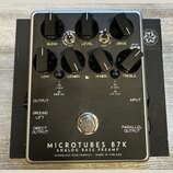 Černý kytarový pedál s kovovým rámem a nápisem MICROTUBES B7K ANALOG BASS PREAMP DARKGLASS ELECTRONICS - MADE IN FINLAND. Zařízení má osm ovládacích…