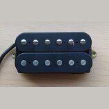 Černý humbucker s dvěma řadami šesti snímačů. Horní řada má viditelné šroubovací hlavy, spodní řada jsou hladké čepy. Na komponentu nejsou viditelné…