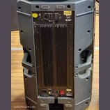 Zadní strana černého aktivního subwooferu v plastovém pouzdře. V horní části je ovládací panel s nápisy INPUT, OUTPUT, LINE/MIXED, PHASE a LOW CUT /…