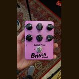 Růžový kytarový efekt s šesti černými ovládacími knoflíky. Na pedálu jsou nápisy LOW, MID, HIGH, LEVEL, VOICE a DRIVE, značka RAZZOR PEDAL. Ve spodní…