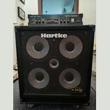 Černý basový reproduktor s kovovou mřížkou, na které je bílý nápis Hartke a v pravém dolním rohu žlutý štítek XL Series 4.5XL. Nad reproduktorem je u…