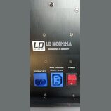 Detail zadní strany černého elektronického zařízení s kovovým povrchem. Je zde uveden nápis LD SYSTEMS, model LD MON121A a text ENGINEERED IN GERMANY…