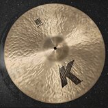 Kulatý mosazný činel s kovaným povrchem. Na povrchu je černý nápis RIDE 20"/51 cm a velké černé písmeno K. V pravé horní části je drobný, nečitelný n…