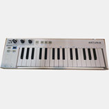 Bílá klávesová kontrola s nápisem ARTURIA a sloganem YOUR EXPERIENCE YOUR SOUND. V levé části je označení KEYSTEP CONTROLLER & SEQUENCER a ovládací p…