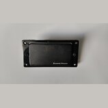 Černý kytarový snímač s krytem. V pravém dolním rohu je bílý nápis Seymour Duncan. Snímač je umístěn v černé rámečku s otvory pro šrouby. Povrch kryt…