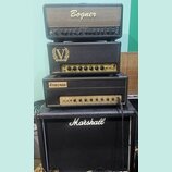 Stack čtyř kytarových zesilovačů v černém provedení. Z horního je vidět nápis Bogner, druhý má logo VICTORY a nápisy Volume 1, Treble, Middle, Bass,…
