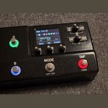 Černý kytarový efekt s displejem a ovládacími prvky. Na displeji je vidět text „02A Torn SC“ a „Kinky Comp“ s parametry Sens 5.0, Mix 100% a Attack 0…