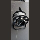 Černý plastový náviják s kovovým spodním rámem, na kterém je namotán šedý kabel. Na kabelu je viditelný konektor. Nástroj nemá žádné viditelné značky…
