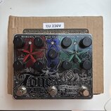 Stříbrný efektový pedál s nápisem electro-harmonix a MULTI EFFECT. Zařízení obsahuje tři sekce označené jako MEMORY TOY, NEO CLONE a METAL MUFF, s od…