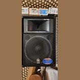 Černý reproduktor s kovovou mřížkou a hornem ve horní části. Na hornu je nápis Extra Band a v pravém dolním rohu logo YAMAHA. V dolní části mřížky je…