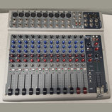 Stříbrný mixážní pult s modrými a červenými ovratovými knoflíky. V pravém horním rohu je nápis PV14 USB a v pravém dolním rohu logo Peavey. Zařízení…