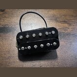 Černý humbucker s dvěma řadami šesti polkových snímačů. Nástroj nemá žádné viditelné značky ani nápisy. Z těla vychází černý kabel s bílým vodičem.