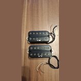 Dvě černé humbuckery s viditelnými snímačmi a připojeným kabelážím. Horní snímač má bílý nápis V8 a spodní snímač má bílý nápis V7. Oba jsou umístěny…