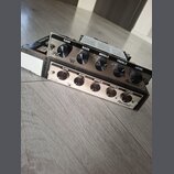 Dvě kytarové zesilovače s kovovým předním panelem a černými ovládacími knoflíky. Horní jednotka má nápisy GAIN, BASS, MIDDLE, TREBLE, LEVEL a logo Ra…