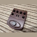 Hnědý kytarový pedál s nápisy V-TONE ACOUSTIC ADI 21 a COURTIC MODELER DRIVER DI. Na horní části jsou umístěny čtyři otočné knoflíky s popisky TREBLE…