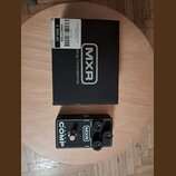 Černý kytarový efekt pedál s nápisem Super COMP a logem MXR. Na horní straně jsou tři ovládací knoflíky s popisky OUTPUT, ATTACK a SENSITIVITY. Vedle…
