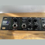 Černý rackový zesilovač sluchátek s nápisem HEAD AMP 6 PRO a popiskem PROFESSIONAL SIX CHANNEL HEADPHONE AMPLIFIER WITH EQ AND AUXILIARY MIXER. Na př…