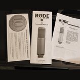 Fotografie zobrazuje tři papírové dokumenty k mikrofonu. Uprostřed je „K2 Instruction Manual“ od značky RØDE MICROPHONES s obrázkem stříbrného mikrof…