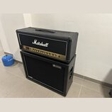 Kytarový zesilovač Marshall DSL umístěný na kytarovém cabinetu značky revoltage. Horní kombo má černý texturovaný povrch, zlatý ovládací panel a bílé…