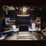 Fotografie zachycuje pracovní místo s hudební technikou. Jsou zde dva studiové monitory značky FOCAL, notebook, externí klávesnice a myš. V popředí j…