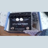 Kytarový efekt v černé barvě s kovovým povrchem a nápisem ehx torsion JFET OVERDRIVE. Na spodní části je uveden výrobce electro-harmonix a web WWW.EH…