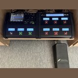 Dvě černé kytarové jednotky Fractal Audio Systems umístěné vedle sebe na dřevěném stole. Levý přístroj má nápis FM3 MARK II AMP MODELER / FX PROCESSO…
