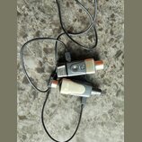 Dvě stříbrno-černé elektronické zařízení připojená k černým kabelům. Na spodním zařízení je viditelné logo Xvive a označení modelu U3. Horní zařízení…