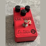 Červený kytarový efekt s nápisem BIG MUFF Pi 2 a DUAL OP-AMP. Na spodní části je logo electro-harmonix, podpis R.E. Myer a nápis NEW YORK CITY, USA s…