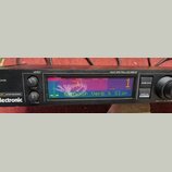 Černý kytarový procesor s nápisem electronic a označením GUITAR PROCESSOR. Zařízení má Multi Spectral LCD Display, na kterém je zobrazen text G-Major…