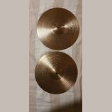Dvě zlatavé kovové činely s koncentrickým rýhováním. Na obou je viditelné logo Paiste a nápis INNOVATION. Povrch je čistý bez viditelných poškzení.