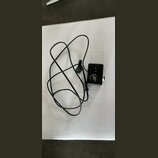 Černý kabel s malým čtvercovým ovládacím modulem. Na modulu je bílý nápis v kurzívě "Alba". Kabel končí malým kulatým senzorem s připevňovacím klipem.