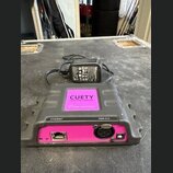 Šedý plastový přístroj s růžovými prvky a nápisem CUETY. Na zadní straně jsou viditelné konektory označené jako ETHERNET a DMX-512. K přístroji je př…