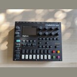 Černý polyfonní digitální syntetizátor s nápisy Polyphonic Digital Synthesizer a Digitone. V pravém horním rohu je logo elektron. Zařízení obsahuje d…