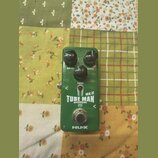 Zelený kytarový efekt pedál s nápisy DRIVE, LEVEL a TONE u ovládacích knoflíků. Uprostřed je bílý nápis TUBE MAN MK II OVERDRIVE s ikonou vakuumové t…