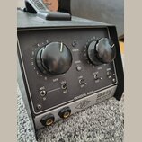 Černý rackový přístroj s nápisem UNIVERSAL AUDIO SOLO/610 Classic Vacuum Tube Mic Pre & DI Box. Přední panel obsahuje dva velké černé otočné ovladače…