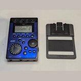Modrý kytarový efekt s displejem, na kterém je nápis VOXWAH. Na horní části je značka ToneWorks a model X-Bass, vlevo nápis BEMS. Zařízení obsahuje n…